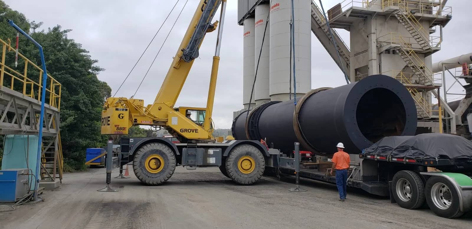 Multi-axle stretch RGN hauling a heavy steel pressure vessel secured with straps.