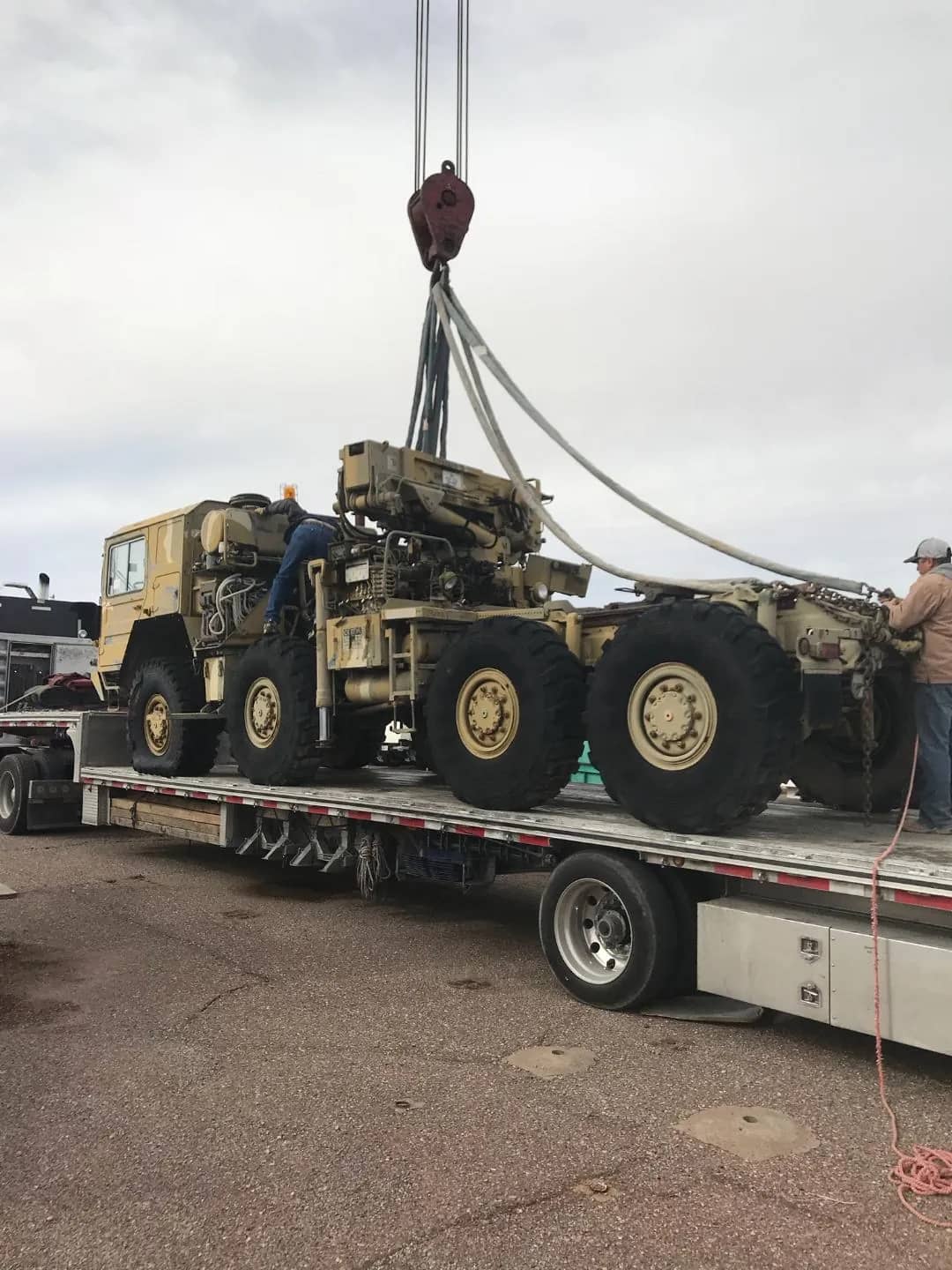 Tall machinery secured on a step deck during delivery.